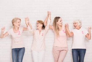 4 women holding hands up and cheering